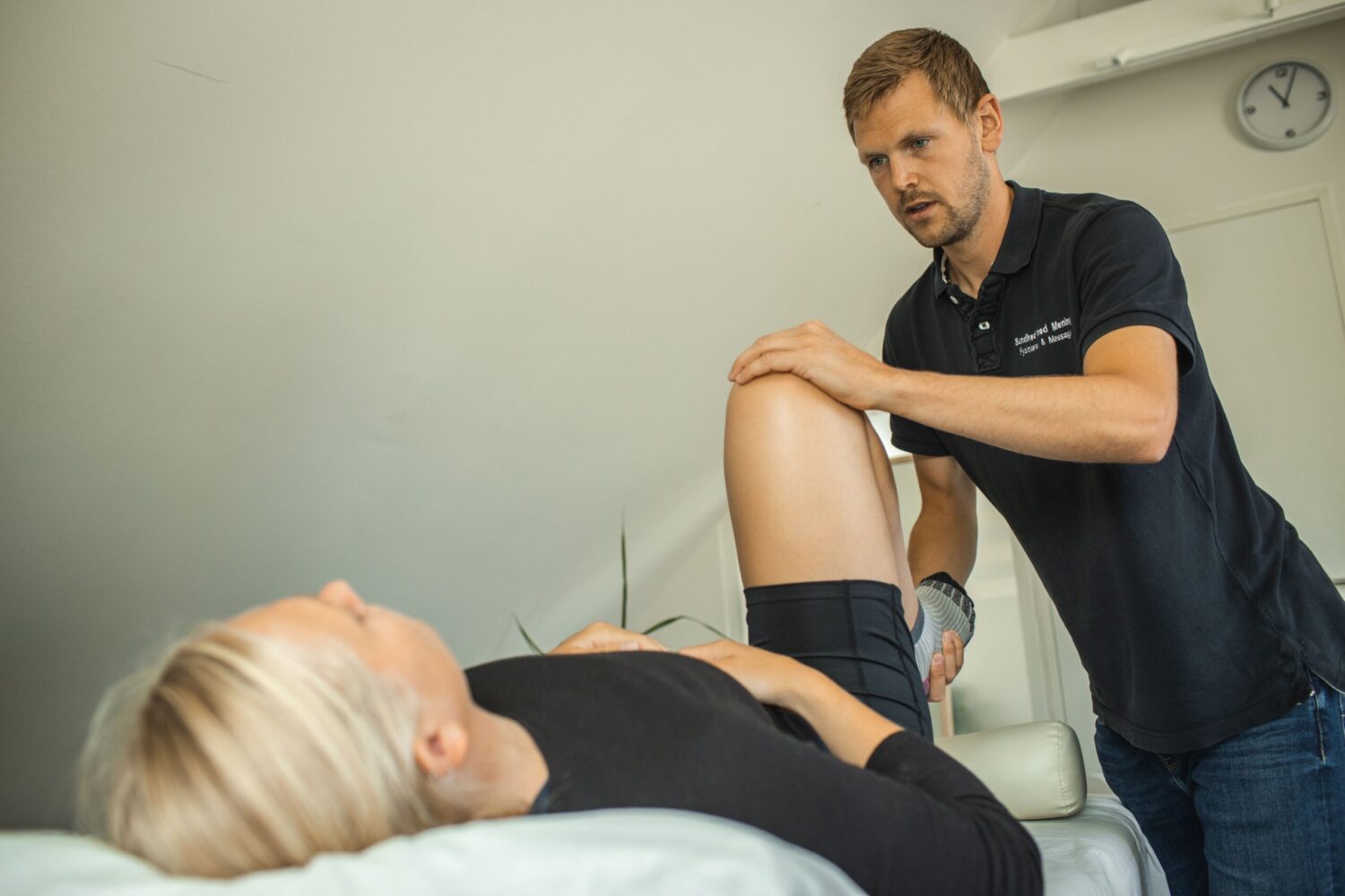 Fysioterapeut undersøge knæ på kvinde